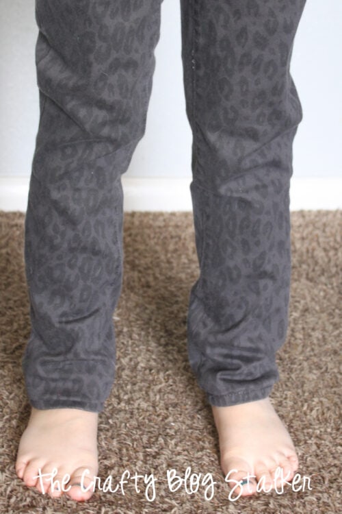 A girl wearing jeans that have been hemmed and fit correctly.