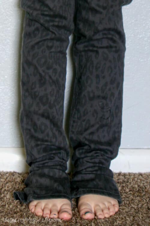 A girl wearing jeans that are too long and hemmed.