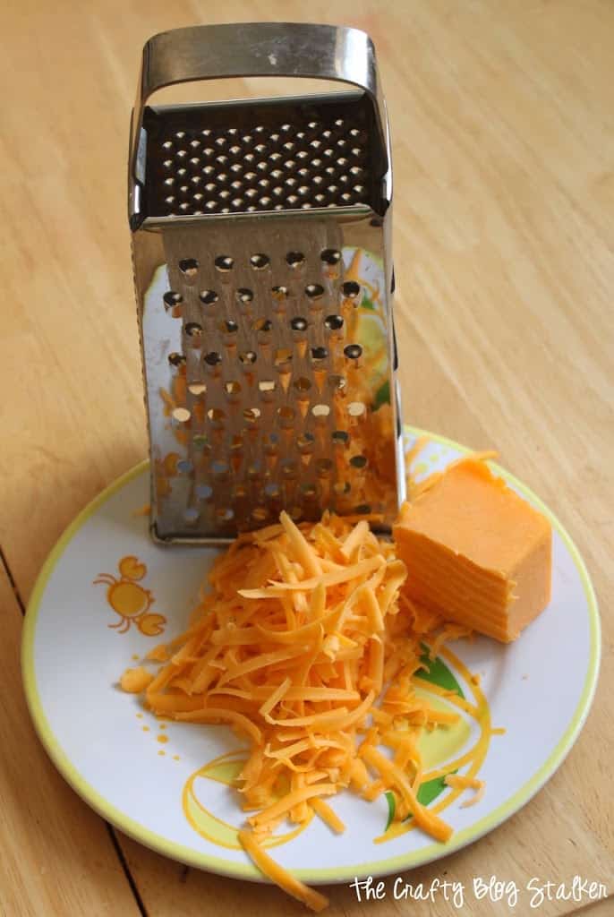 image of cheese grater with shredded chees