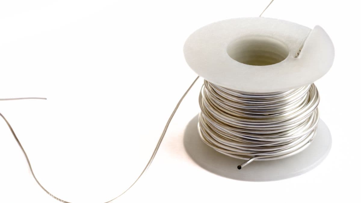 Spool of thin craft wire with loose end extended, shown on a plain background for jewelry making or DIY projects.