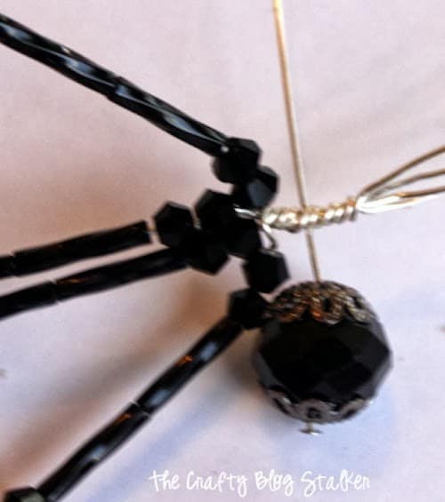 twisting the wire together to connect the legs and the body of the spider