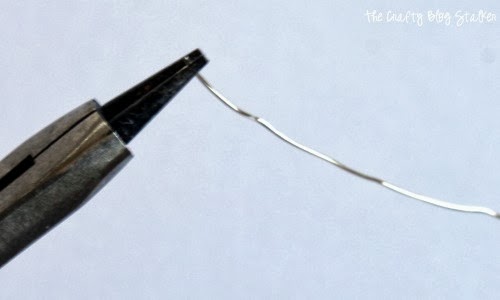 making a loop at the end of a piece of wire with round nose jewelry pliers