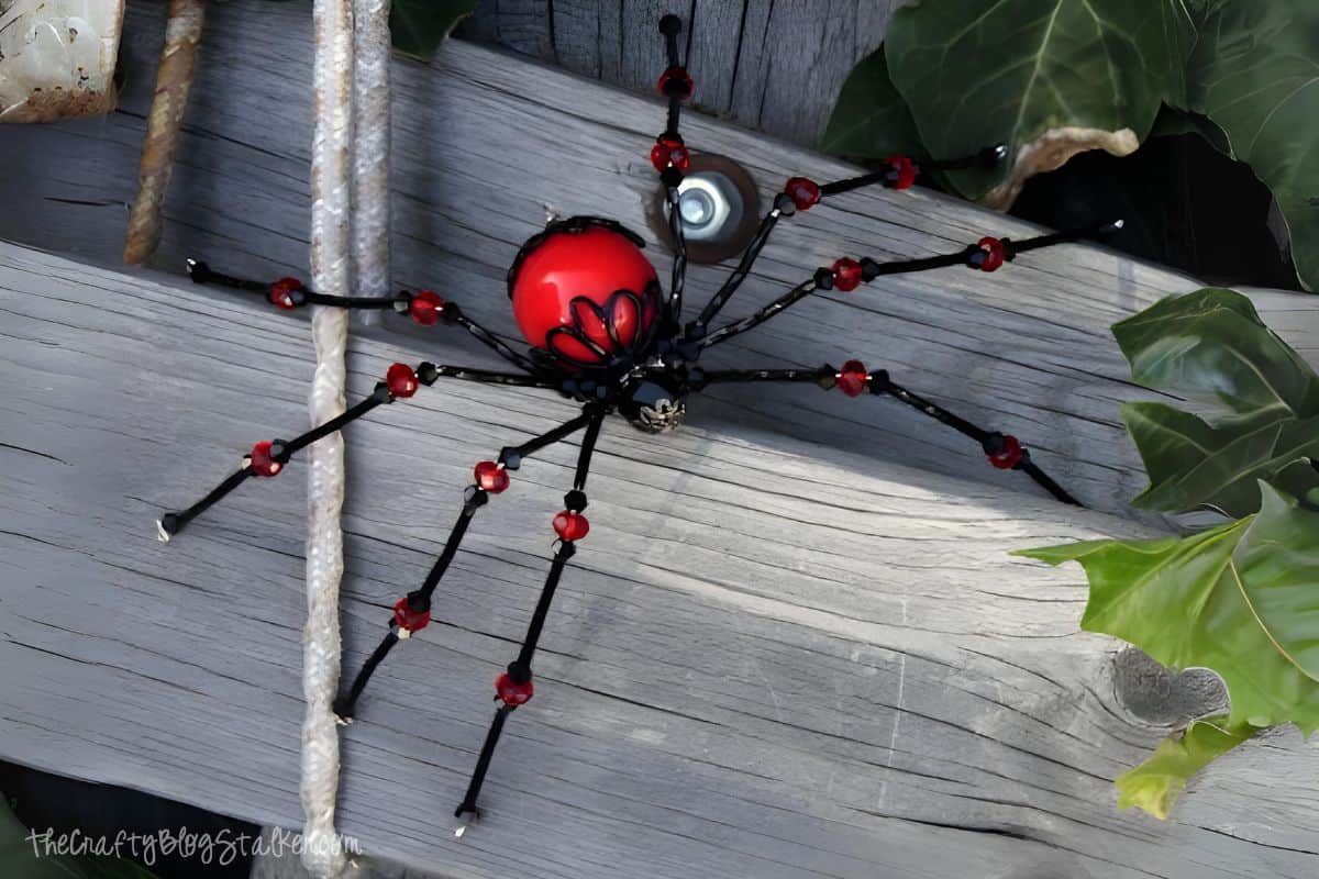 beaded spider on a stack of wood