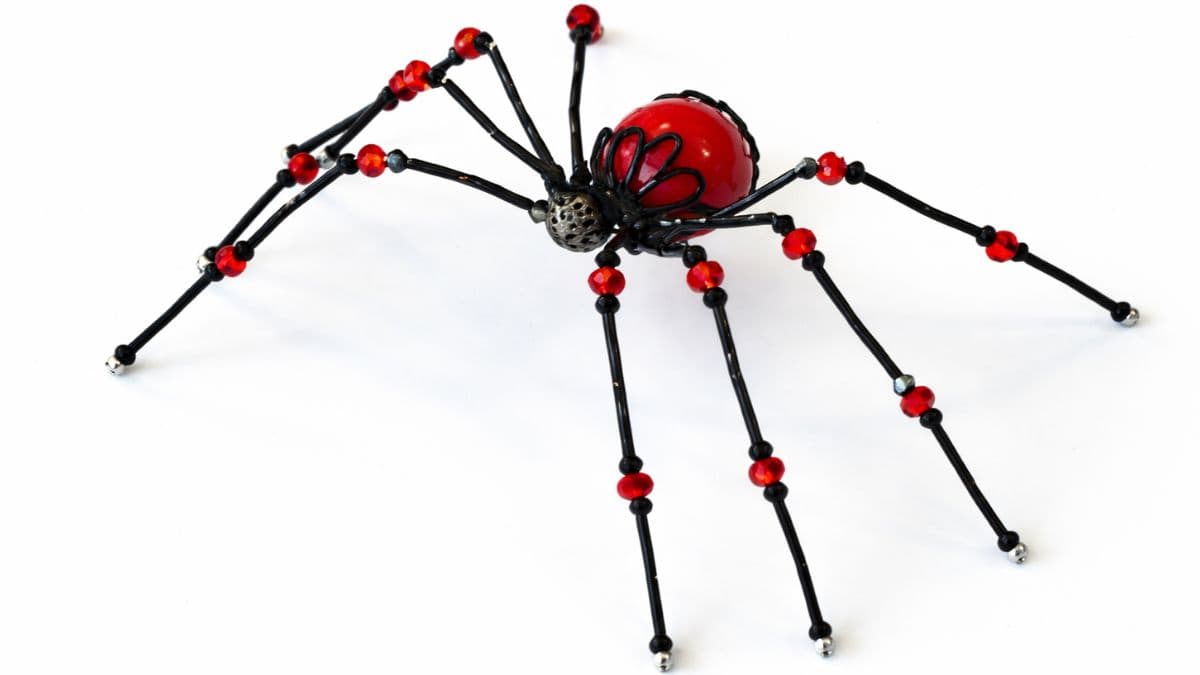 beaded spider on a piece of wood