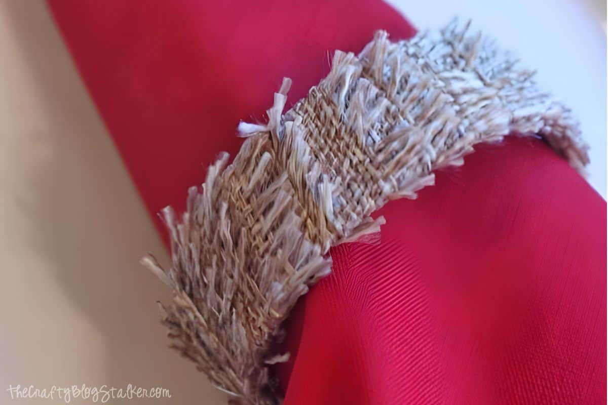Napkin ring made with strips of burlap.