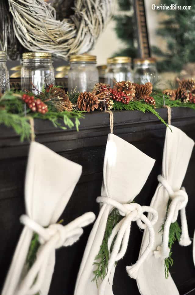 A Rustic Christmas Mantel featuring real cedar garland and drop cloth stockings