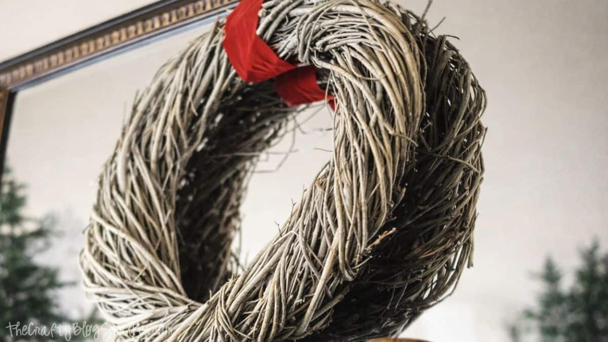 A Rustic Christmas Mantel featuring real cedar garland and drop cloth stockings Close-up of a rustic twig wreath with a simple ribbon hanging above a piano as part of Christmas mantel decor.