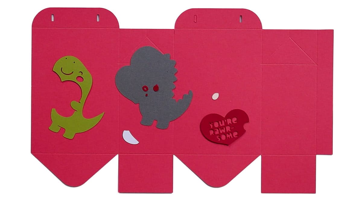Valentine Treat Bag Tutorial #Valentine #PaperCrafts Cut cardstock pieces for a Valentine treat bag laid flat, including dinosaur shapes, a heart message, and folded box panels ready for assembly.