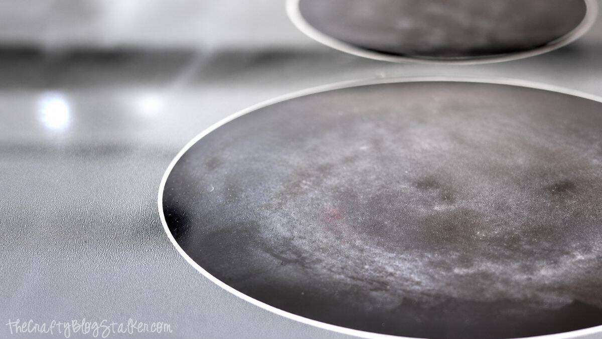 Close-up of a glass top stove burner with cloudy residue and streaks before cleaning and polishing.