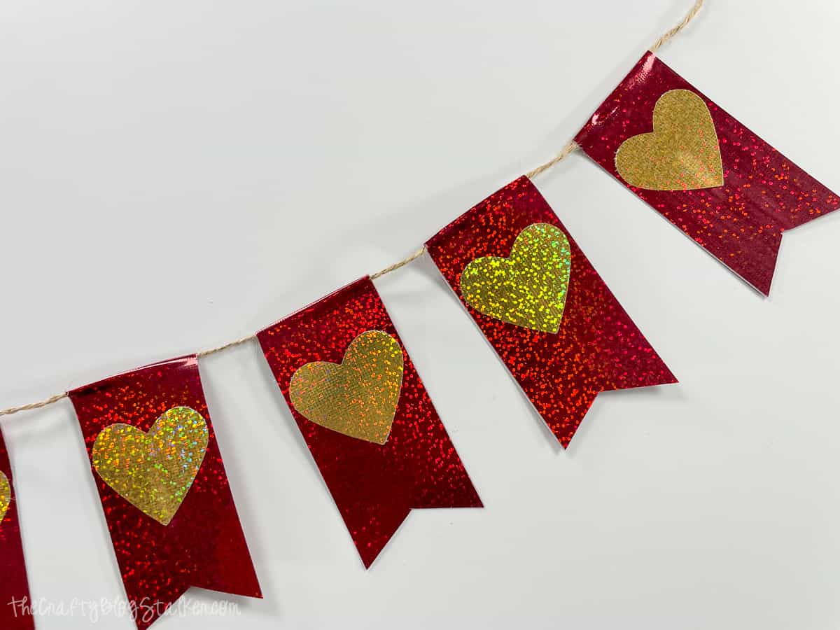 Holographic red pennant banner with gold hearts.