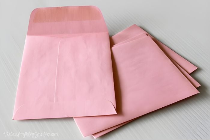 Stack of pink paper envelopes.