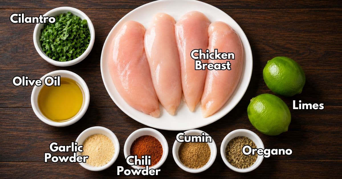 Ingredients for cilantro lime grilled chicken including chicken breasts, cilantro, olive oil, limes, garlic powder, chili powder, cumin, and oregano.