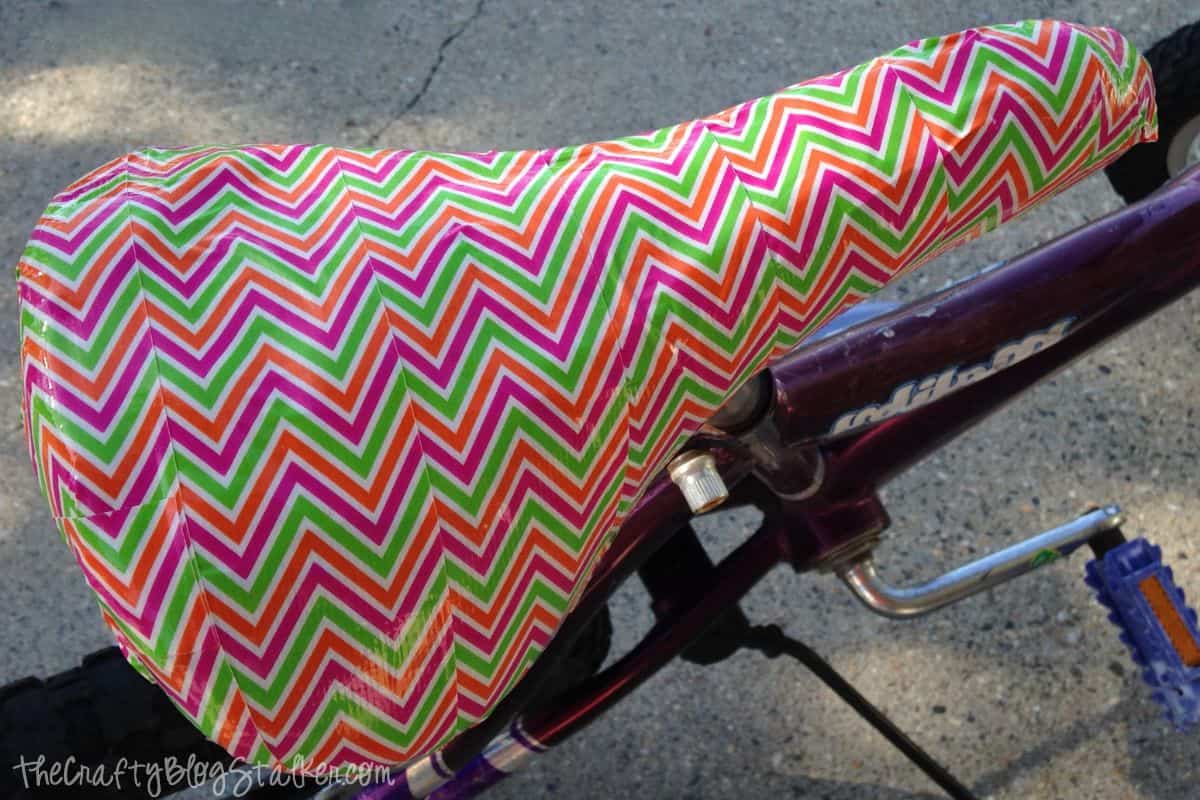 A torn bicycle seat covered with chevron duck tape.