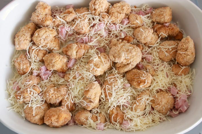 Chicken nuggets, ham, and cheese combined in a casserole dish.