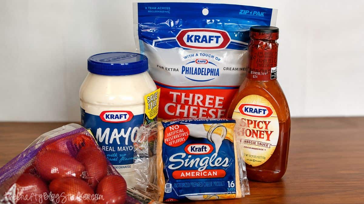 Ingredients for a double bacon cheeseburger including potatoes, mayo, cheese, spicy honey barbecue sauce, and shredded cheese.