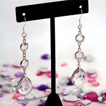 Rhinestone drop earrings displayed on an earring stand.