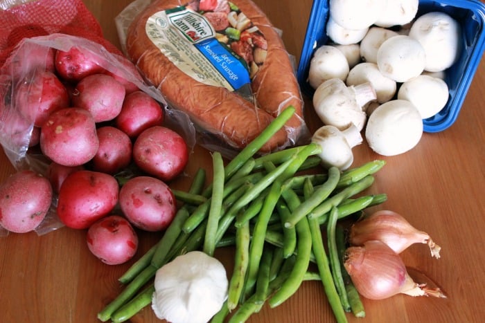 Tinfoil dinner ingredients: kielbasa smoked sausage, mushrooms, green beans, shallots, garlic, and baby red potatoes.