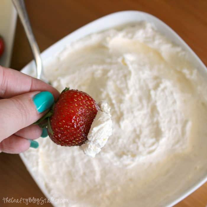 A strawberry dipped into white chocolate fruit dip. Square image.