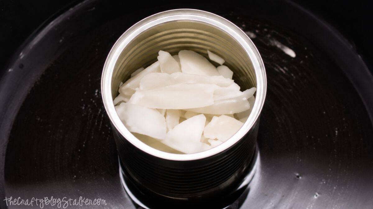 Blikje gevuld met gehakte bijenwas, smeltend in een dubbele boiler, waarmee de was wordt voorbereid voor zelfgemaakte citronellakaarsen.