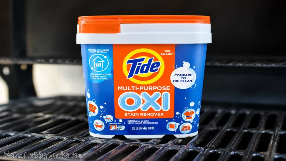 Do you have a gross grill? Learn How to Clean your BBQ Grill fast and easy! Container of Tide Multi-Purpose Oxi stain remover sitting on clean barbecue grill grates after cleaning.