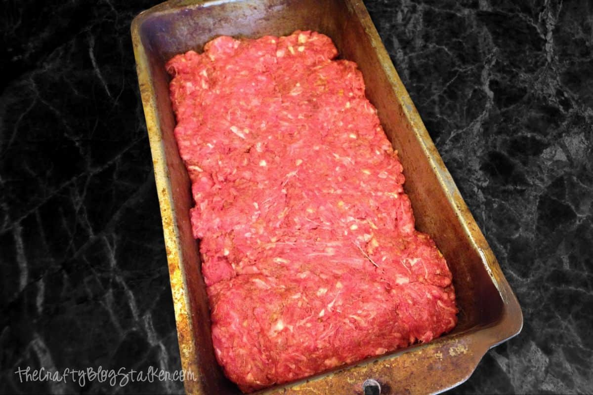 Raw meatloaf mixture in a loaf pan.