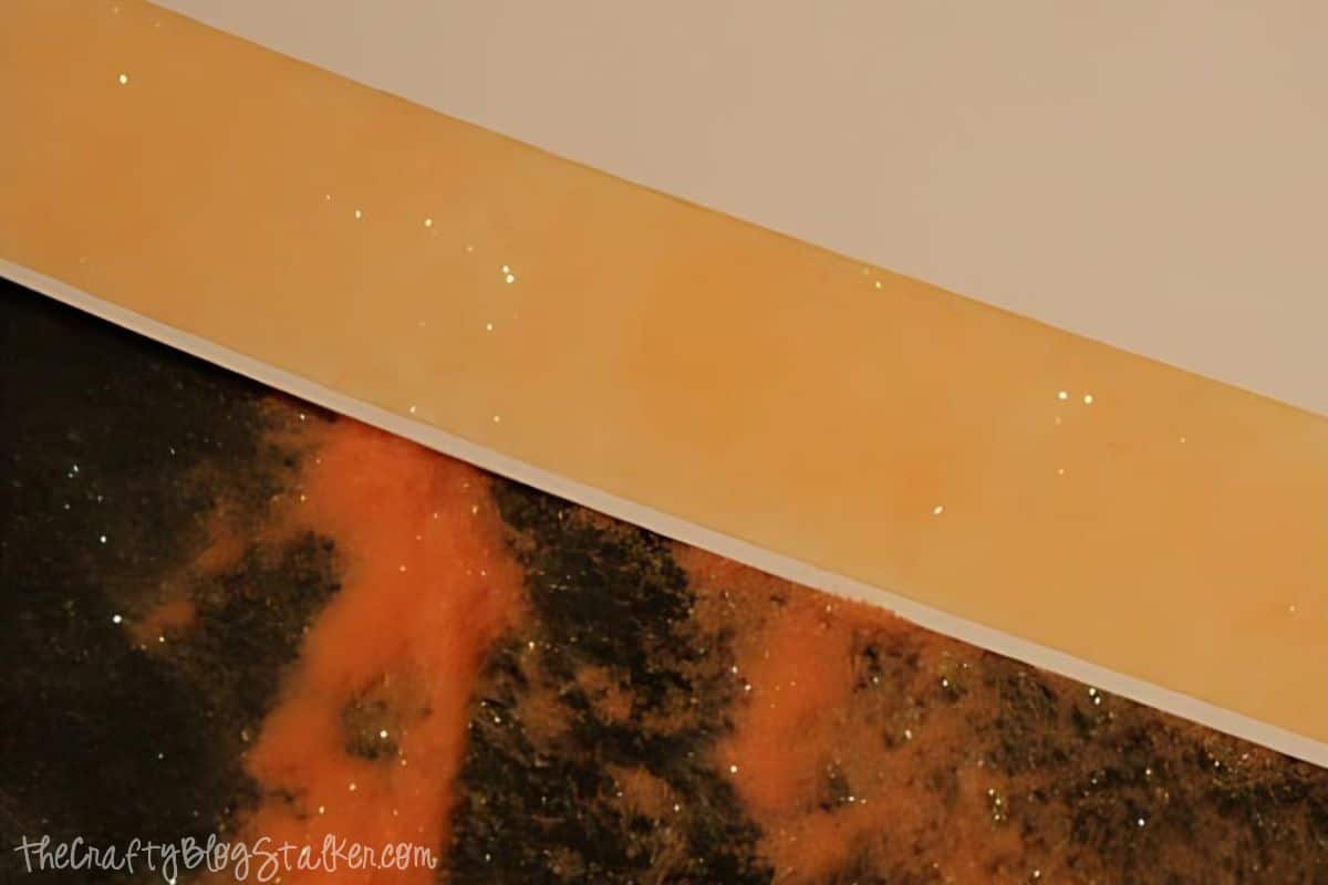 A strip of peach glitter from a length of double sided tape on cardstock.