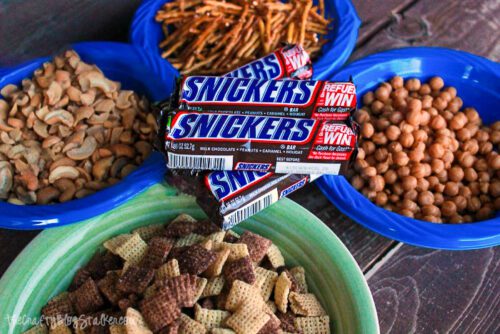 cashews, pretzel sticks, caramel bits, chex cereal and snickers candy bars