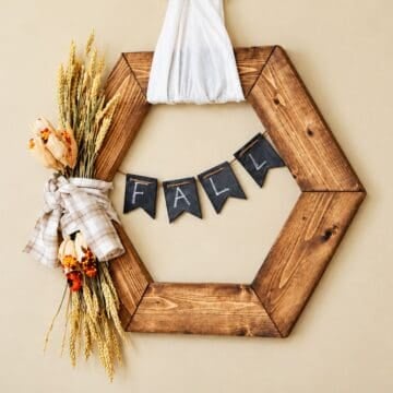 Rustic hexagon wooden fall wreath with fall decorations and a chalkboard banner.