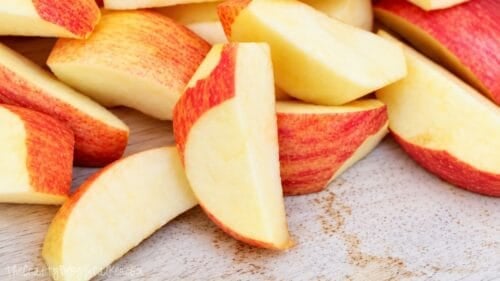 Slices of fresh red and yellow apples for homemade applesauce.