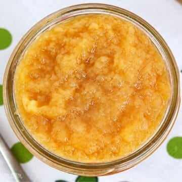 Close-up of homemade unsweetened applesauce in a glass jar.