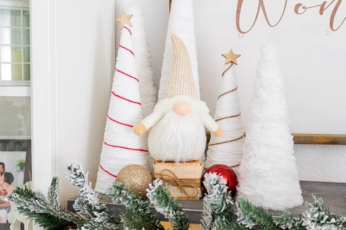 White yarn Christmas trees on a mantel.