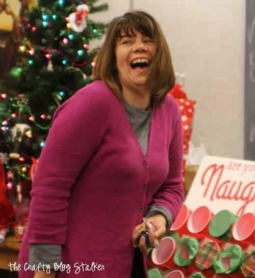 A woman laughing while playing the naughty or nice christmas game.