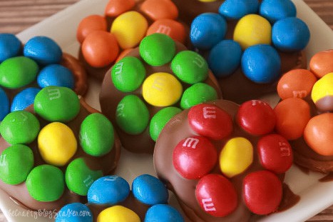 Easy Pretzel treats on a white plate made with different colors of M&Ms.