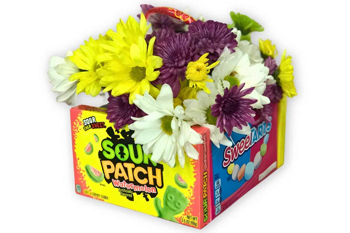 Candy basket filled with a flower arrangement.