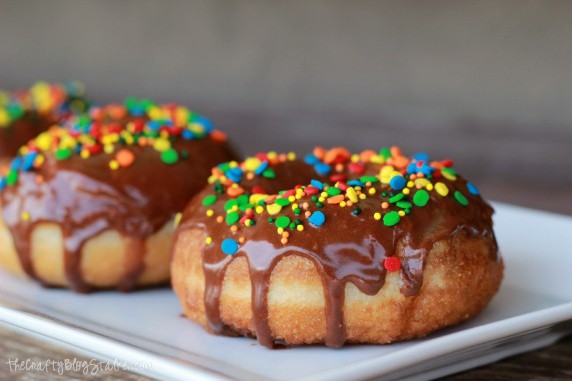 Chocolate glazed donuts on a white plate.