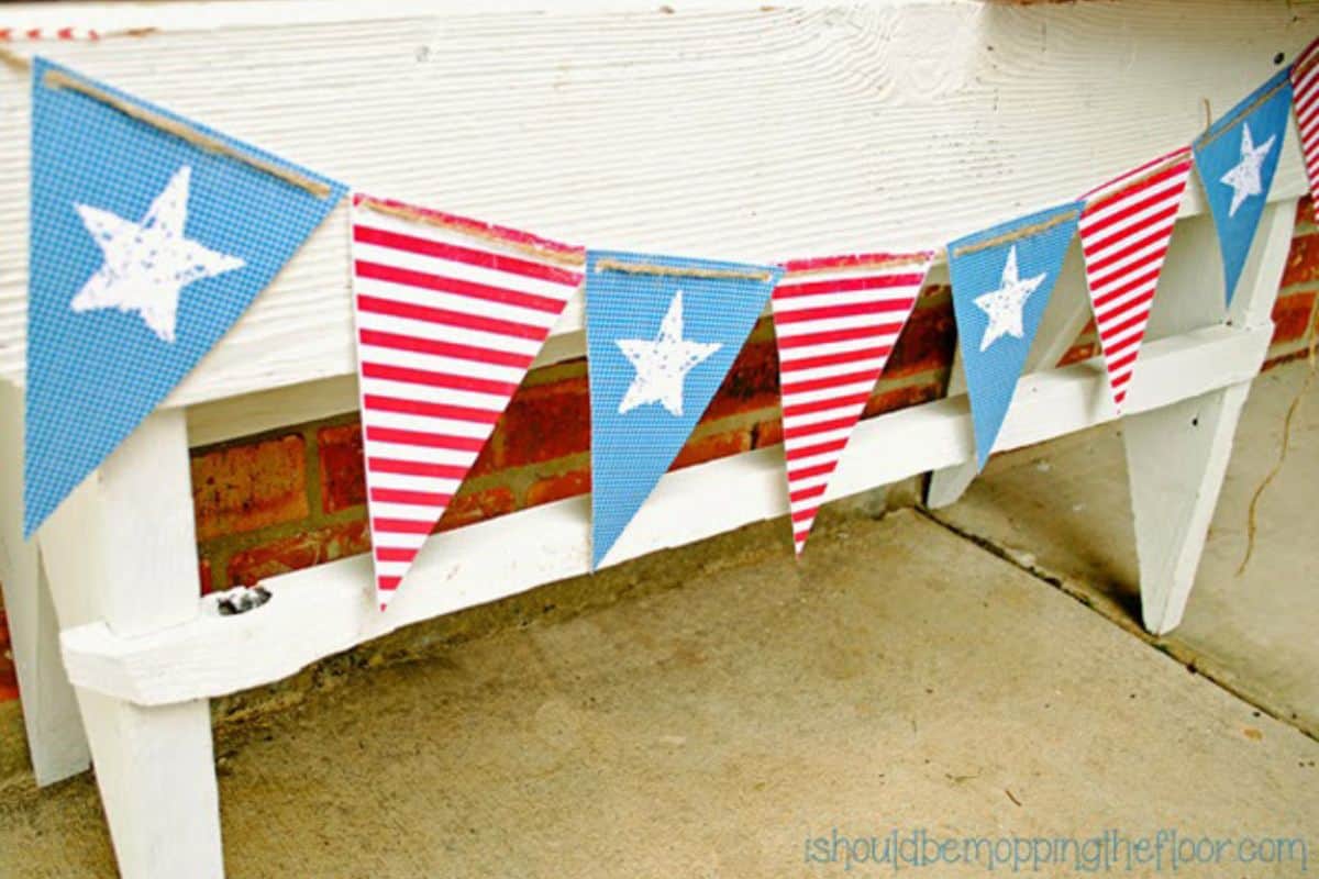 Printable patriotic banner with stars and stripes handing in front of a table.