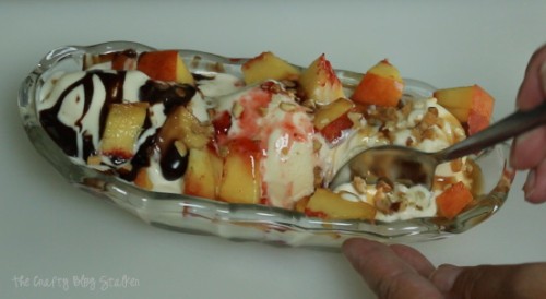 image of taking a spoonful of fresh peach ice cream sundae