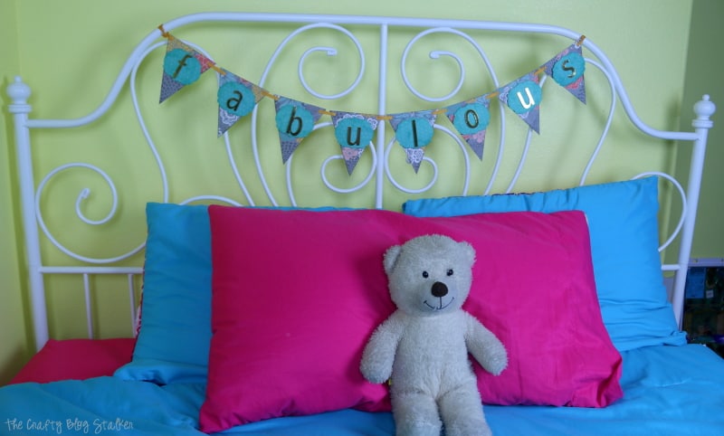 fabulous paper pennant banner hanging on a white metal headboard