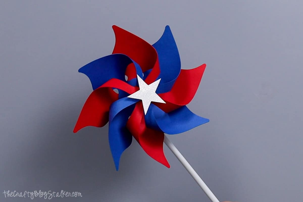 Red white and blue paper pinwheel with a white glitter star on the front.