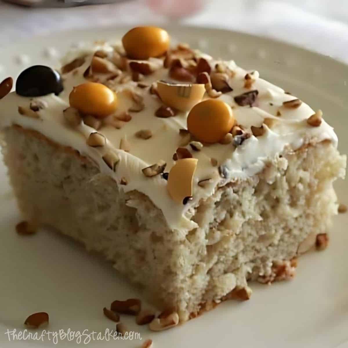 A slice of apple cinnamon cake topped with creamy frosting, chopped nuts, and festive candy pieces, showcasing a moist and fluffy texture perfect for fall gatherings.