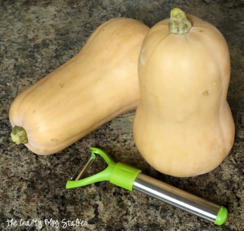 two butternut squash and a vegetable peeler