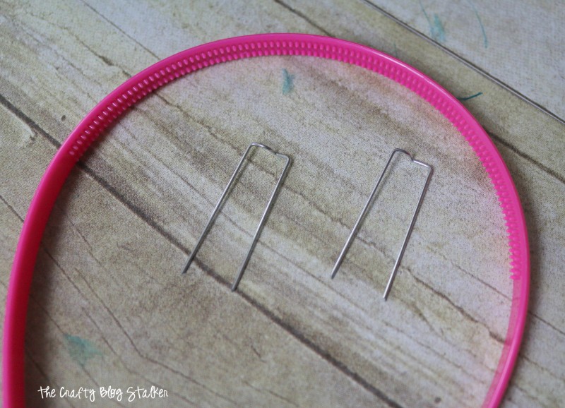 Pink plastic headband and two floral pins.