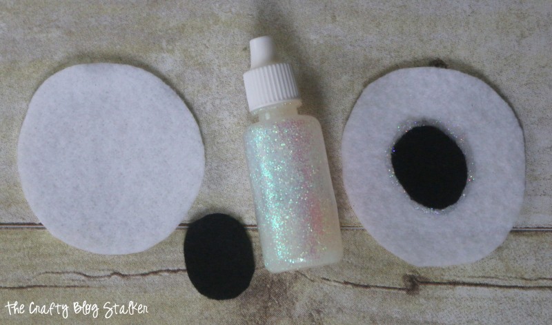 Glitter fabric paint on felt circles to look like eyes.