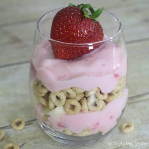 image of a layered breakfast parfait topped with a strawberry