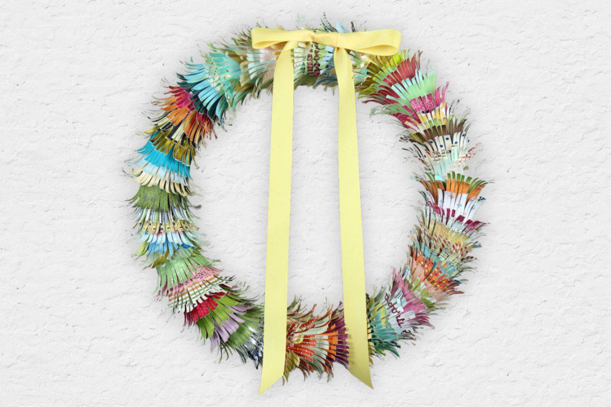 Paper Scrap Fringe Wreath hanging on a wall.