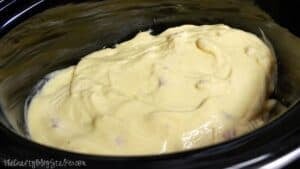 Cream of chicken soup spread over seasoned chicken breasts in a slow cooker before cooking for easy Hawaiian haystacks.