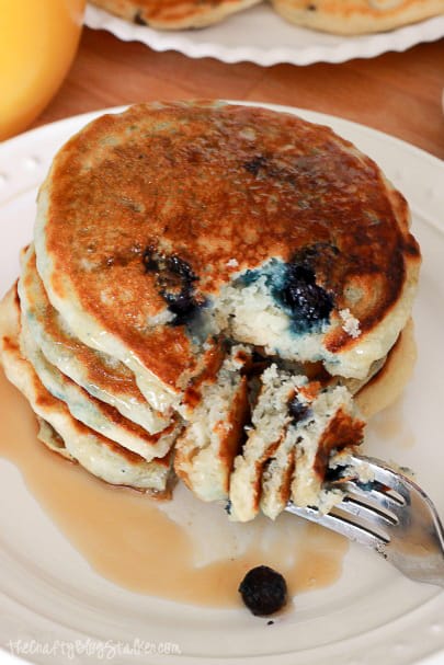 a stack of blueberry pancakes and a fork