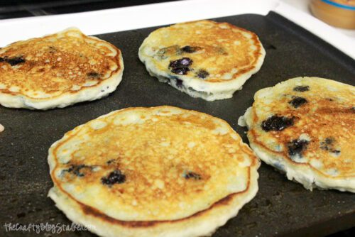 cooking blueberry pancakes on a griddle