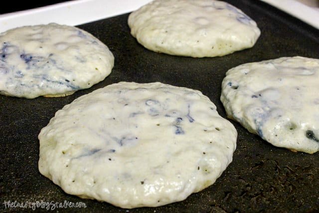 cooking blueberry pancakes on a griddle