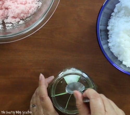 Das weiße Zuckerpeeling in einen Abschnitt des Pintglases geben